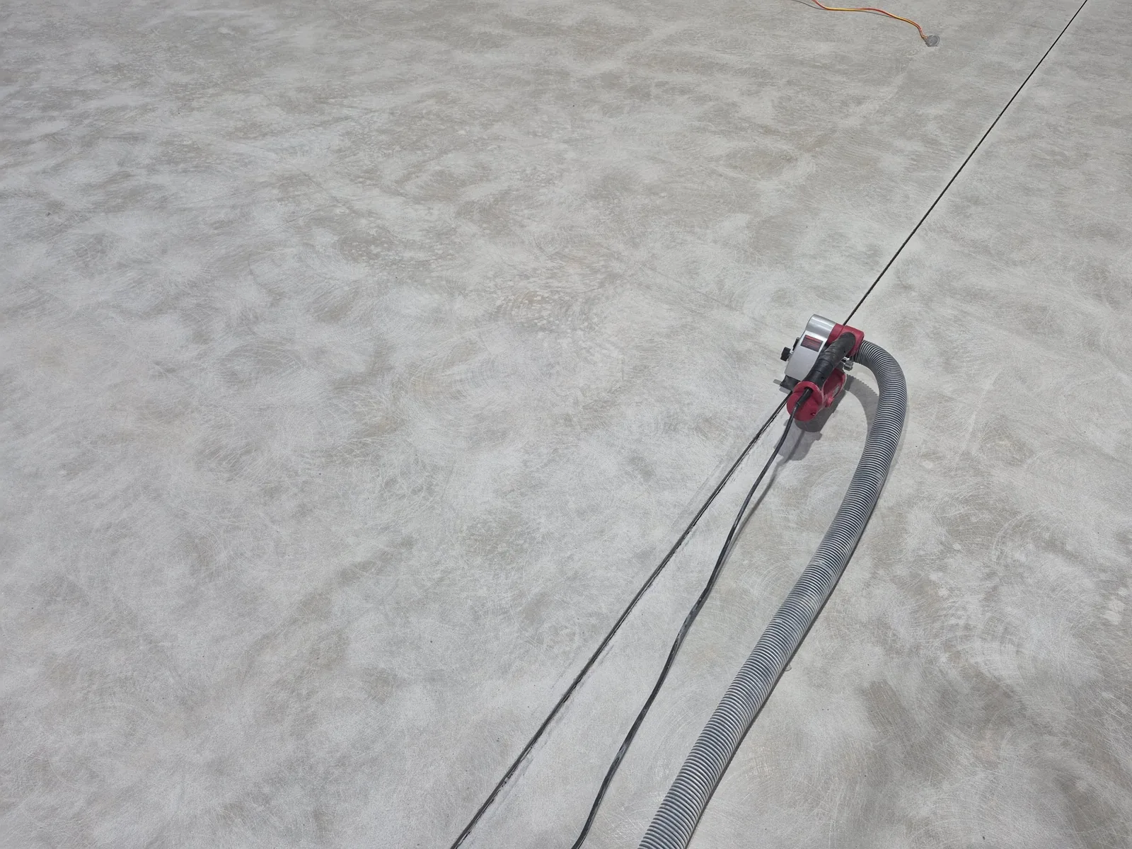 Concrete floor grinding with a connected dust extraction hose